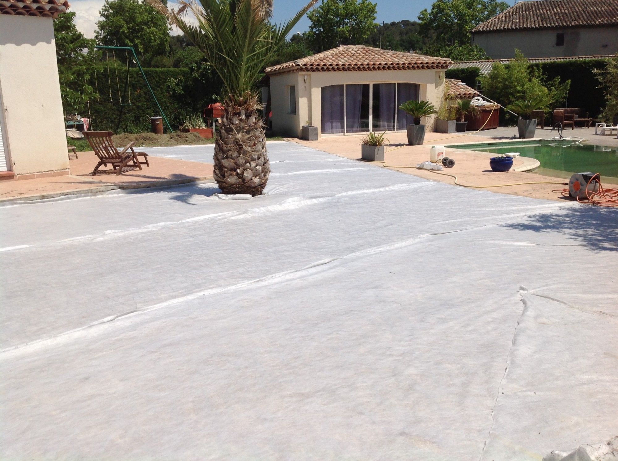 Mise en place du géotextile avant la pose de la pelouse artificielle